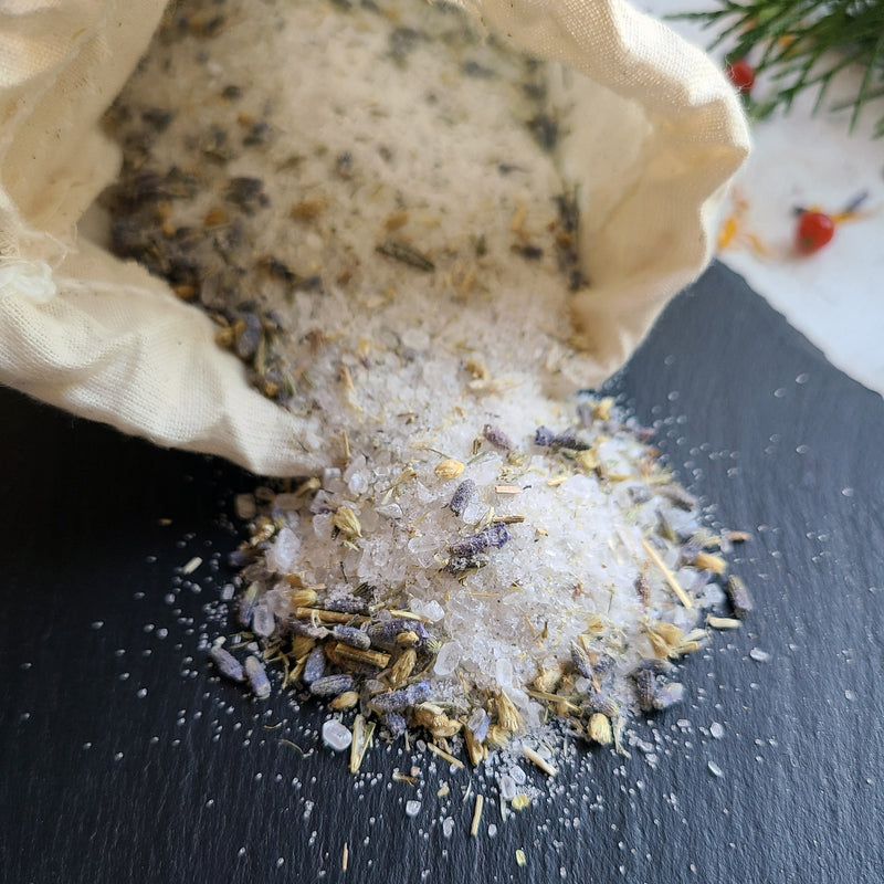 Herbal Foot Soak open bag contents spilling on slate, crystals, lavender petals, yarrow leaves