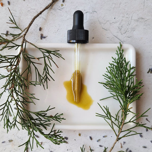 Glow Serum Dropper with rich deep colored oil flecked with shimmer