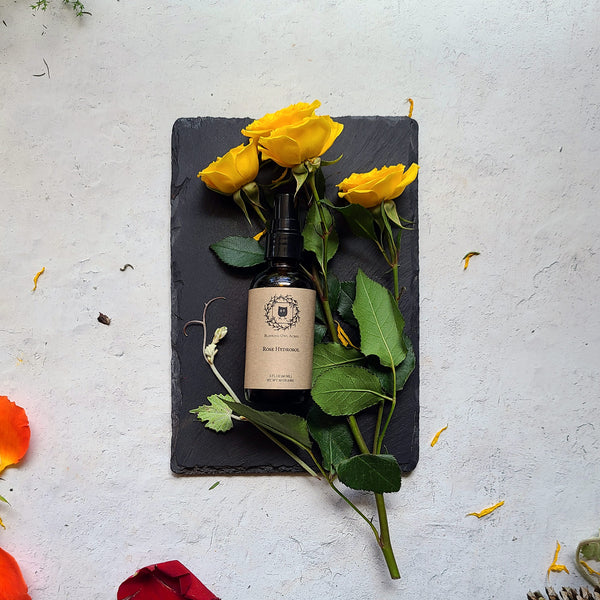 Rose water bottle with roses on slate