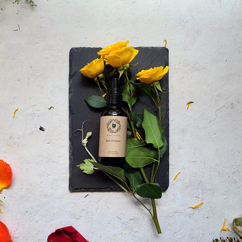 Rose water bottle with roses on slate